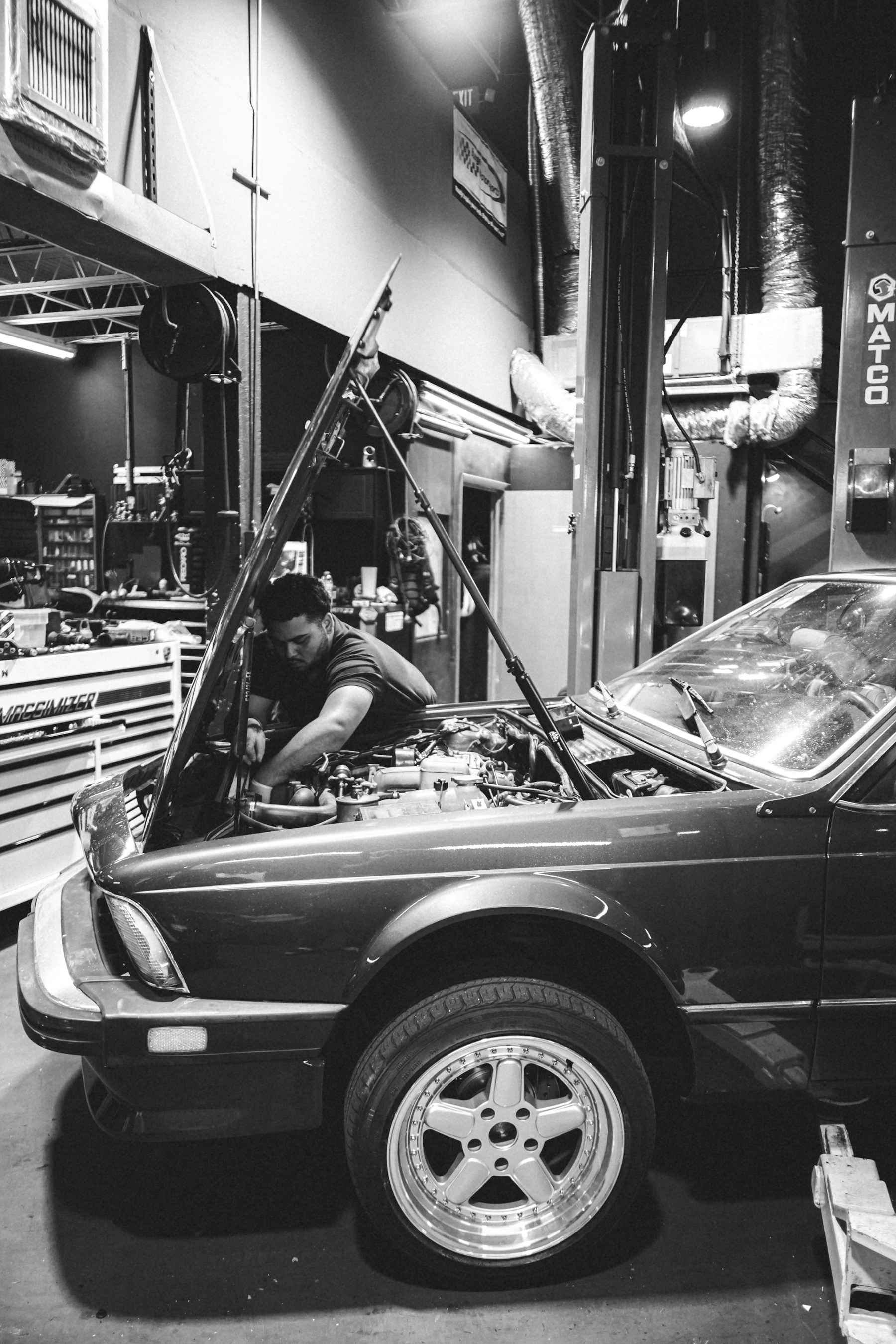 Mechanic working on a vehicle engine in a workshop